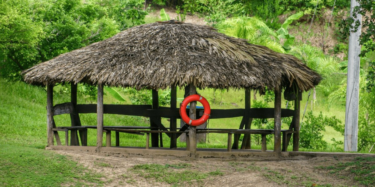 A thatched hut with a life preserver placed on its roof, suggesting a coastal or nautical theme.